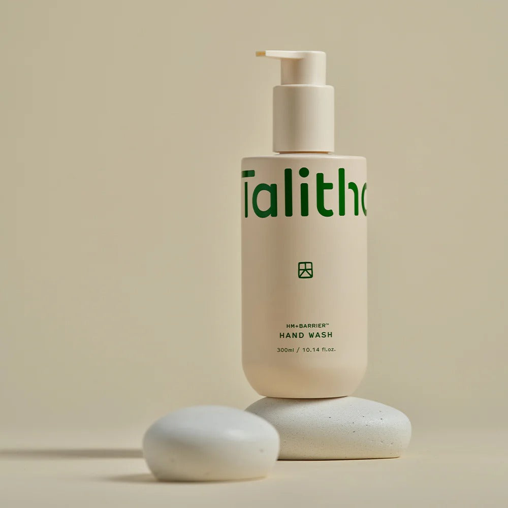 TALITHA KOUM HM+Barrier Hand Wash 300ml bottle on pebble-like stones, beige background, elegant skincare packaging