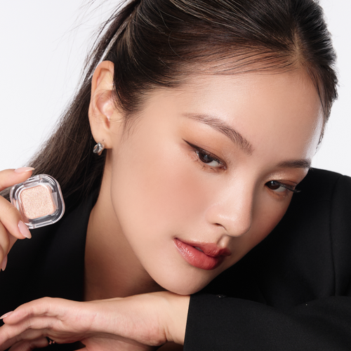 Woman showcasing TONY MOLY Eyetone Single Eyeshadow in natural light, highlighting the product's texture and color.
