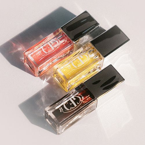TONY MOLY Get It Lip Oil bottles in different shades on a light background, showcasing vibrant colors and sleek packaging.