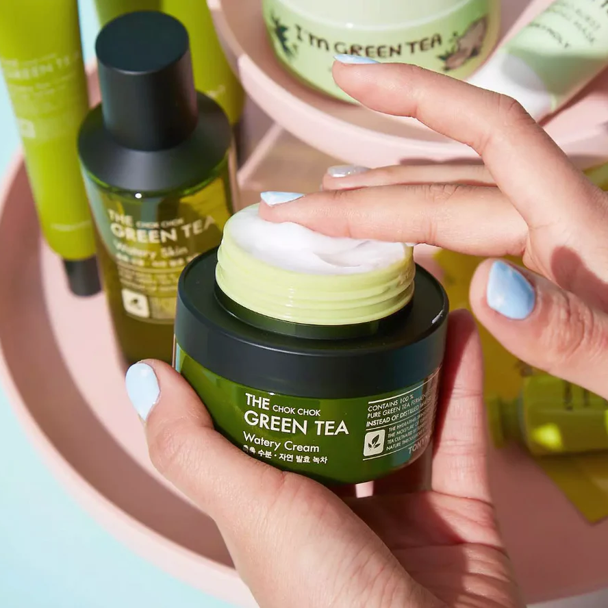 Person applying TONYMOLY More Moist Green Tea Gel Cream 60ml with skincare products in background.