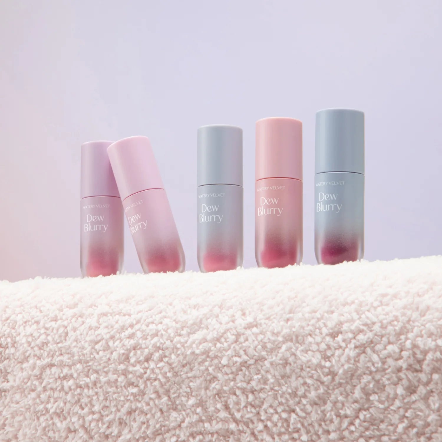 TOO COOL FOR SCHOOL Dew Blurry Tint collection displayed on a soft textured surface, featuring various shades of the product.