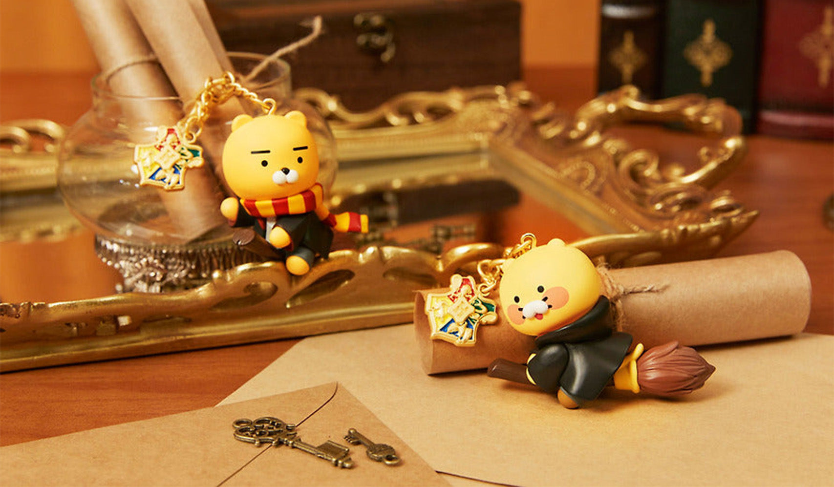 Cute plush toy figures dressed as wizards with themed keychains, displayed on a wooden desk with vintage decor and envelopes.