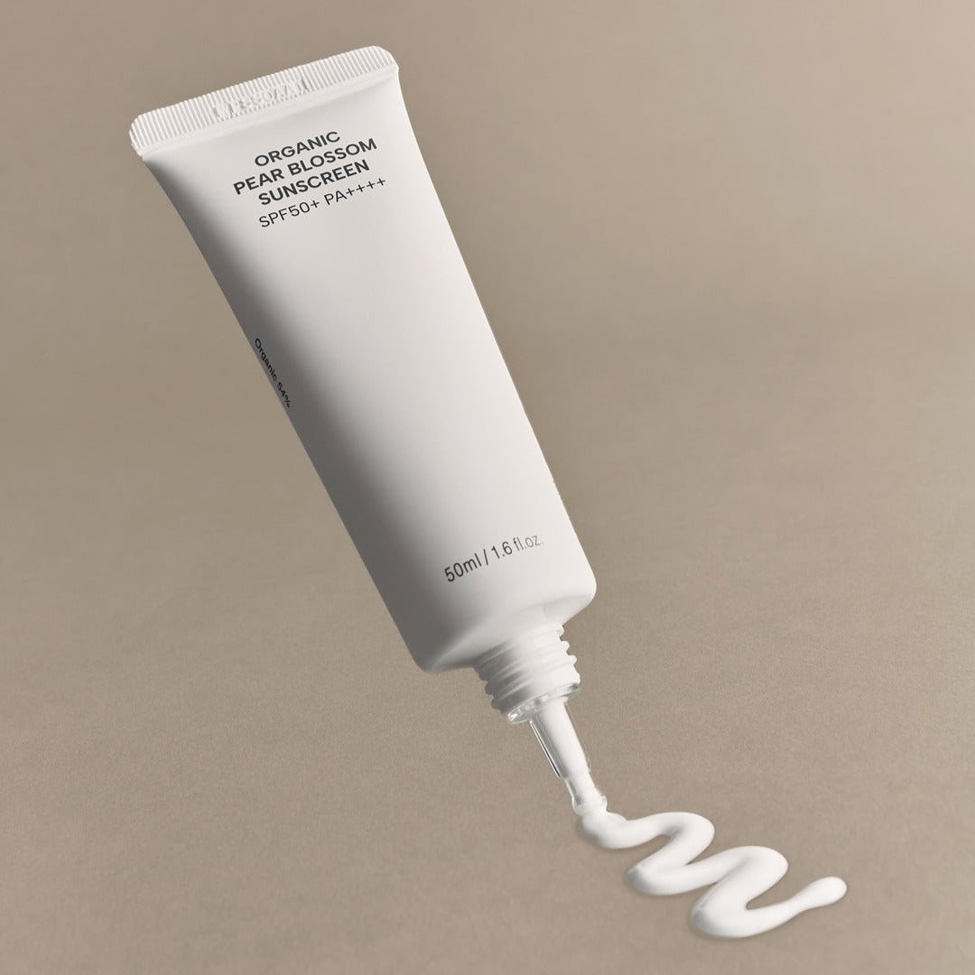WHAMISA Organic Pear Blossom Fermented Sunscreen 50ml packaging with cream swirled on beige background.