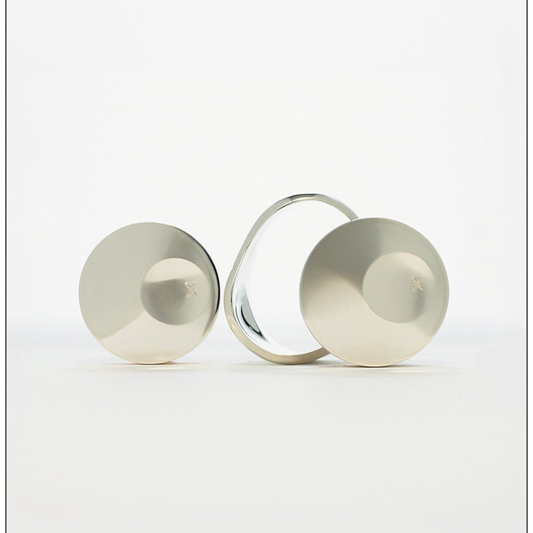 Silver disc-shaped objects with a mirrored surface on a white background.