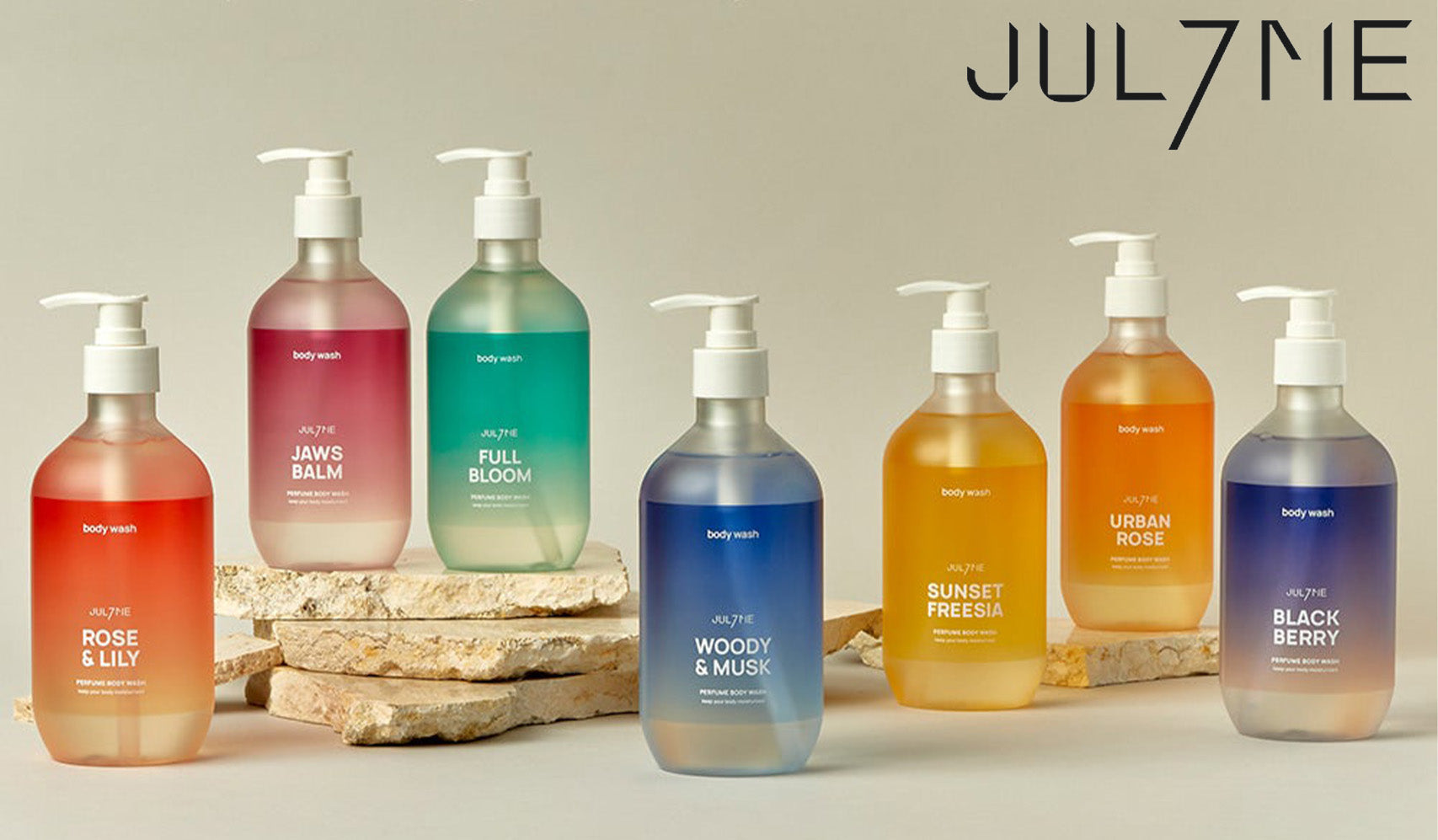Collection of Jul7ne body wash bottles in various fragrances displayed on stone slabs