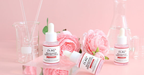 Discover Dr. AG: The Ultimate K-Beauty Experience with skincare serums and pink roses on a pink background