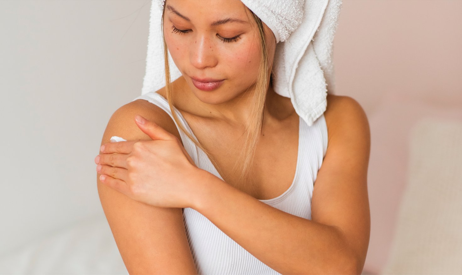 Woman applying lotion as part of Korean Body Care Tips for Smooth, Glowing Skin routine