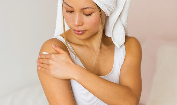 Woman applying lotion as part of Korean Body Care Tips for Smooth, Glowing Skin routine