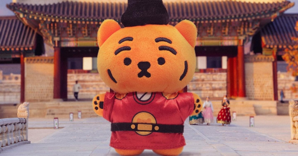 Roar with Style: Dive into the Wild World of Muzik Tiger! Plush toy in traditional attire standing in front of colorful temple.