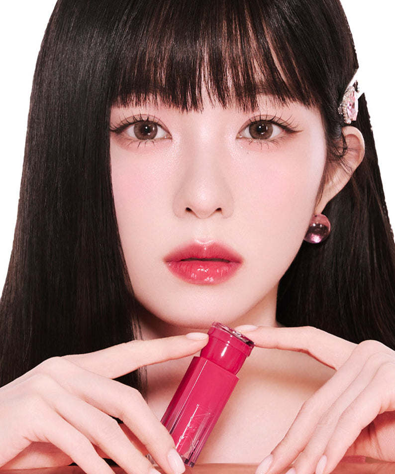 Model holding 2an Glaze Bouncing Tint showcasing vibrant lip color