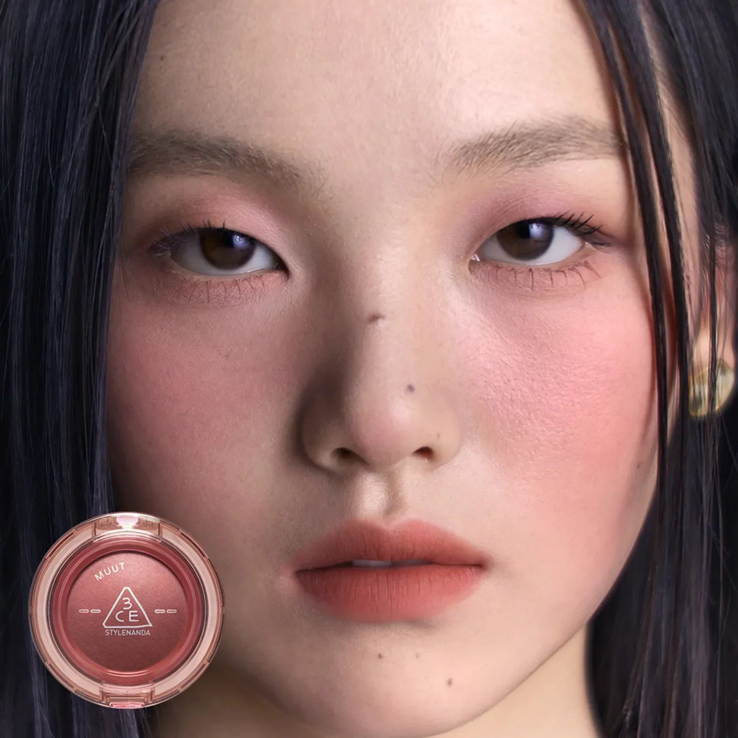 Close-up of model wearing makeup with 3CE Bouncy Blur Balm showcased in a round compact for smooth, flawless skin finish.
