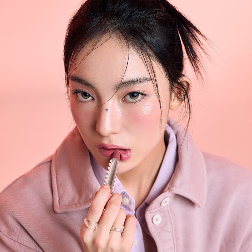Model applying 3CE Glaze Lip Glow 3.2g, showcasing vibrant lip color and smooth texture, perfect for trendy makeup looks.
