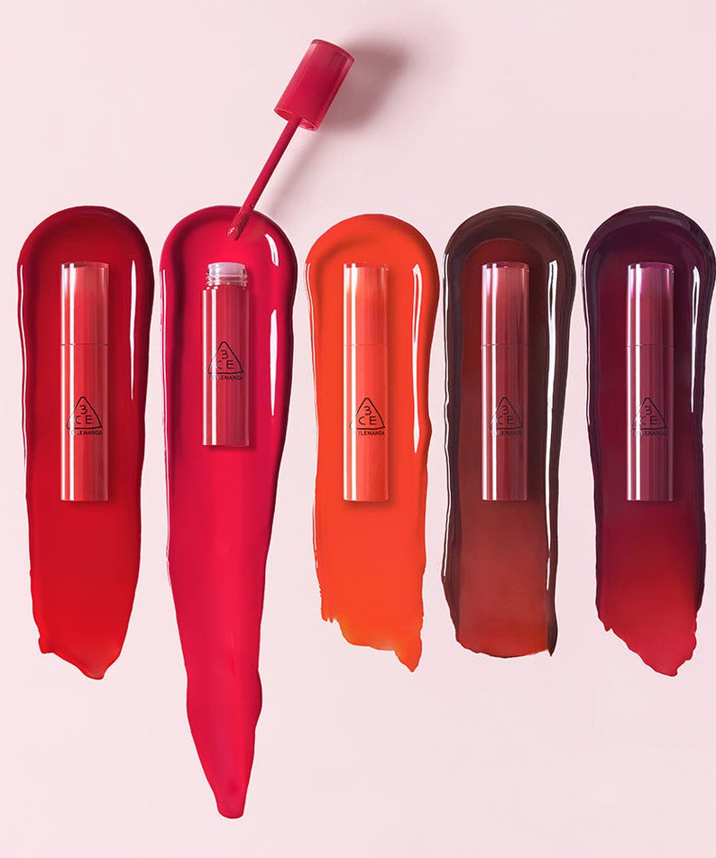 3CE Lazy Pop Lip Stain in various vibrant colors displayed on a light pink background.