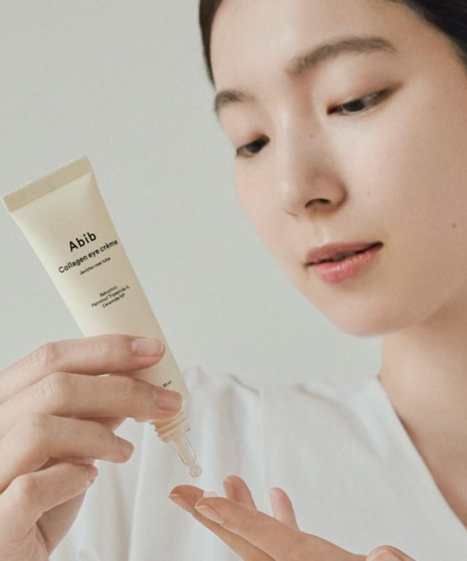 Woman applying ABIB Collagen Eye Cream Resurrection Herb Tube 30ml to her hand