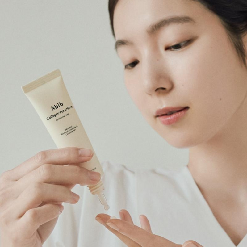 Woman applying ABIB Collagen Eye Cream Resurrection Herb Tube 30ml to her hand