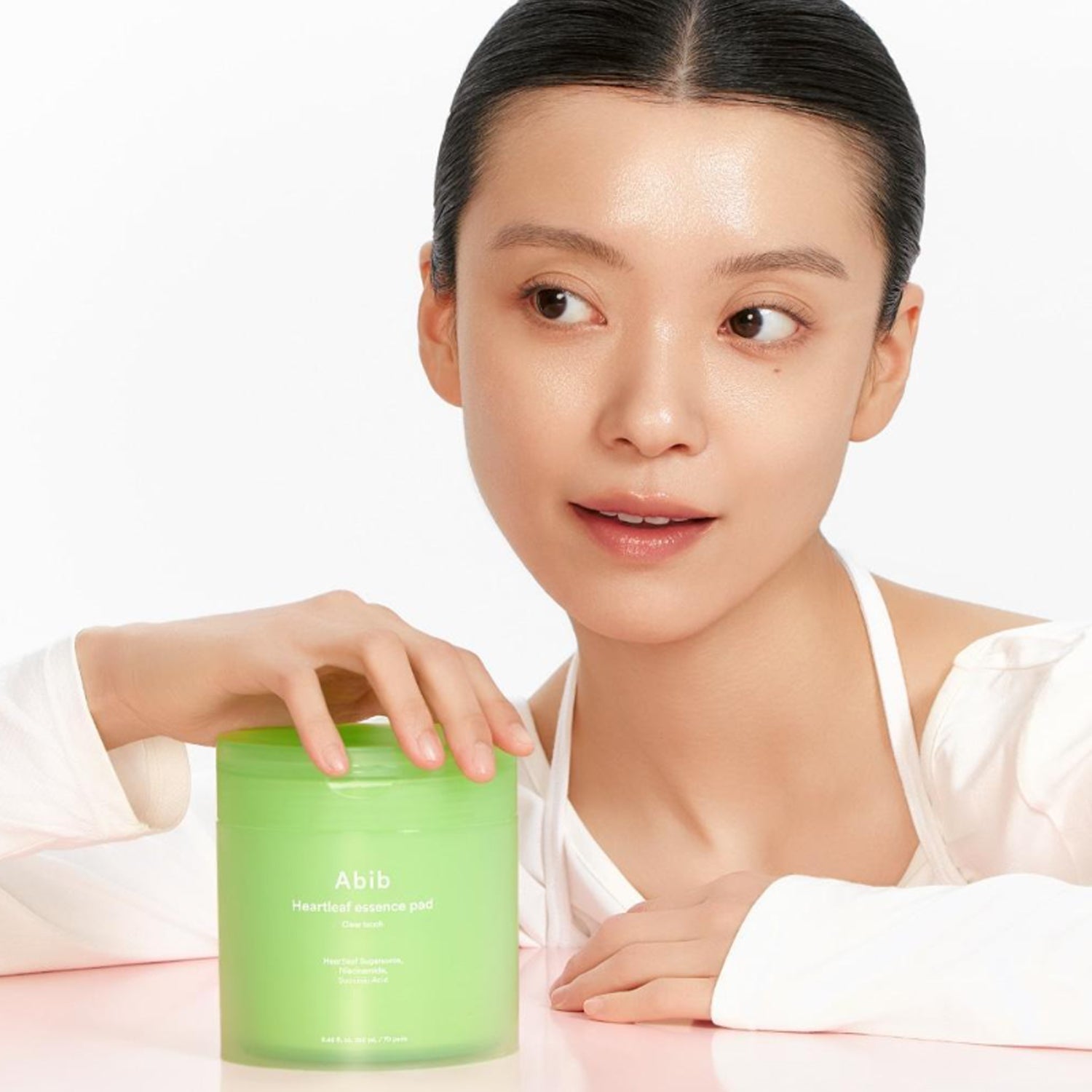 Woman using ABIB Eoseongcho Trace Essence Pad Clear Touch 70 Sheets (+70 Sheets Refill + Buckle Pouch) for skincare routine