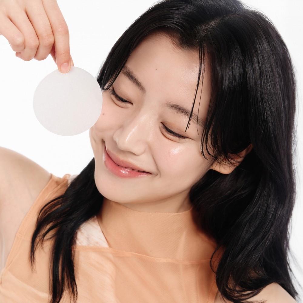 Woman applying ABIB Glutathiosome Dark Spot Pad Vita Touch 60 EA for skincare