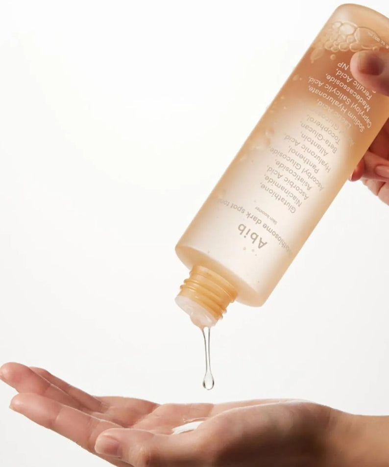 ABIB Glutathiosome Dark Spot Toner Skin Booster 200ml being poured onto a hand for skincare routine.