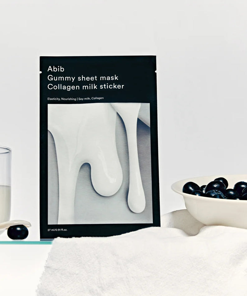 ABIB Gummy Sheets Mask Collagen Milk Sticker 10 sheets packaging next to a glass of milk and blueberries on a white background.