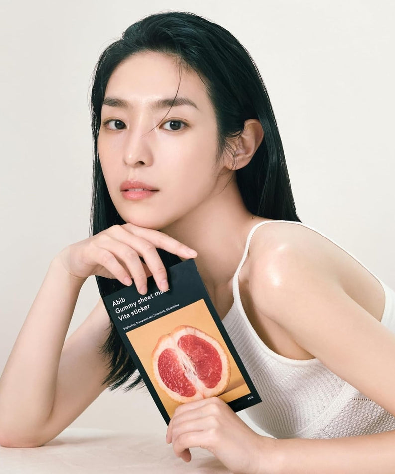Model holding ABIB Gumy Sheet Mask Vita Sticker 10 sheets package with grapefruit design.
