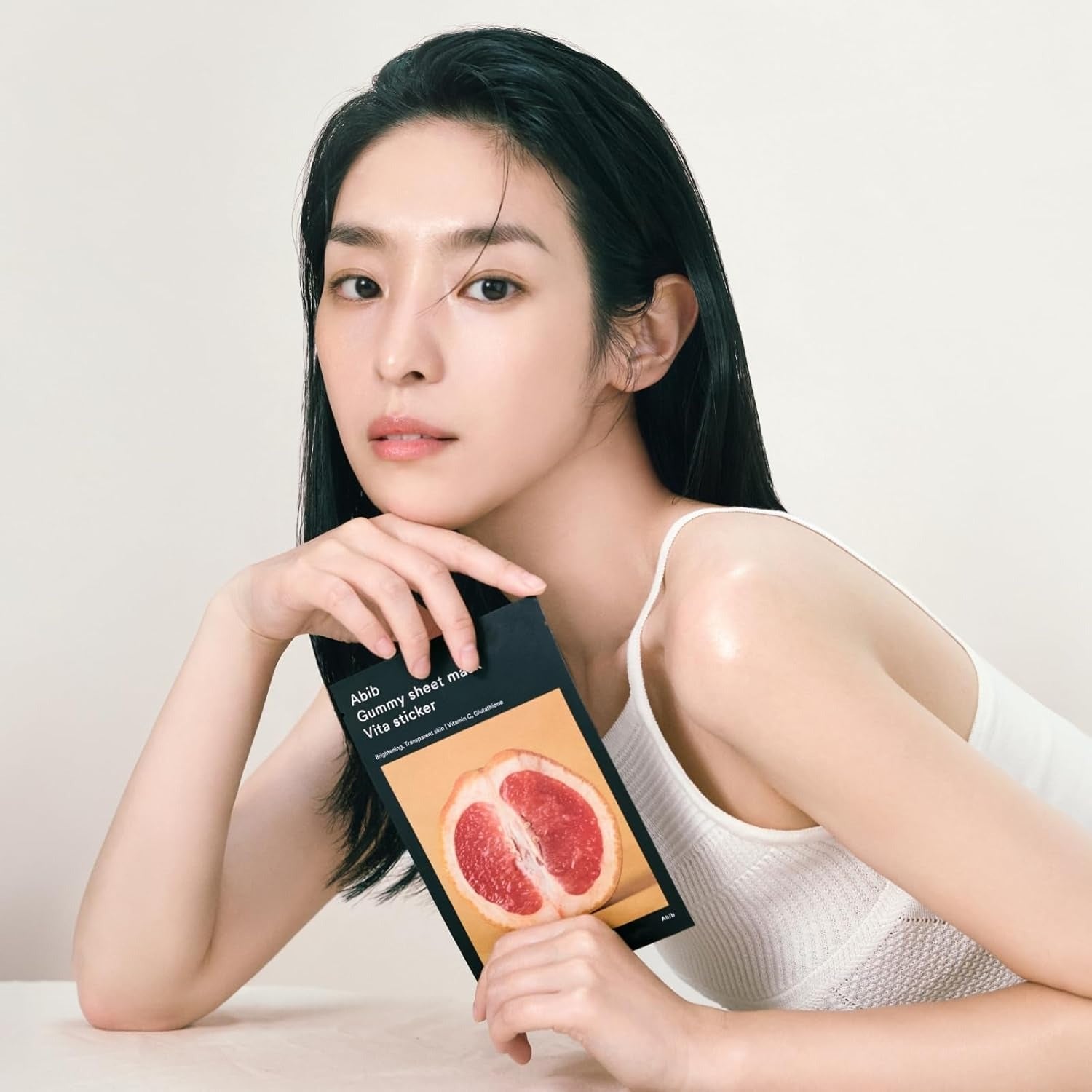 Model holding ABIB Gumy Sheet Mask Vita Sticker 10 sheets package with grapefruit design.