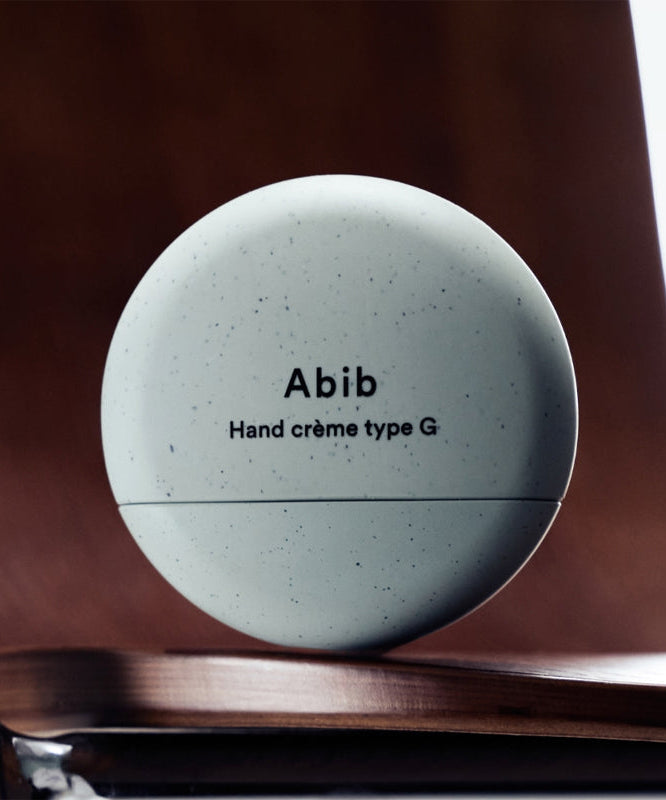 ABIB Hand Cream 3 Types - sleek container design on wooden background.