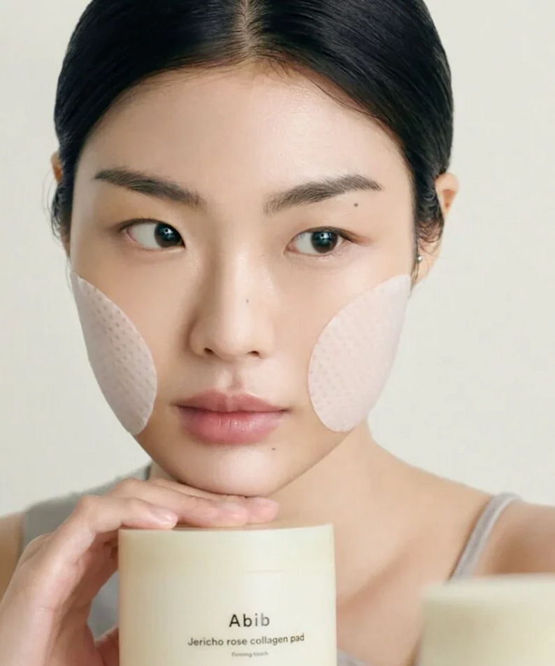 Woman using ABIB Jericho Rose Collagen Pad Firming Touch 60 Pads for skincare routine.