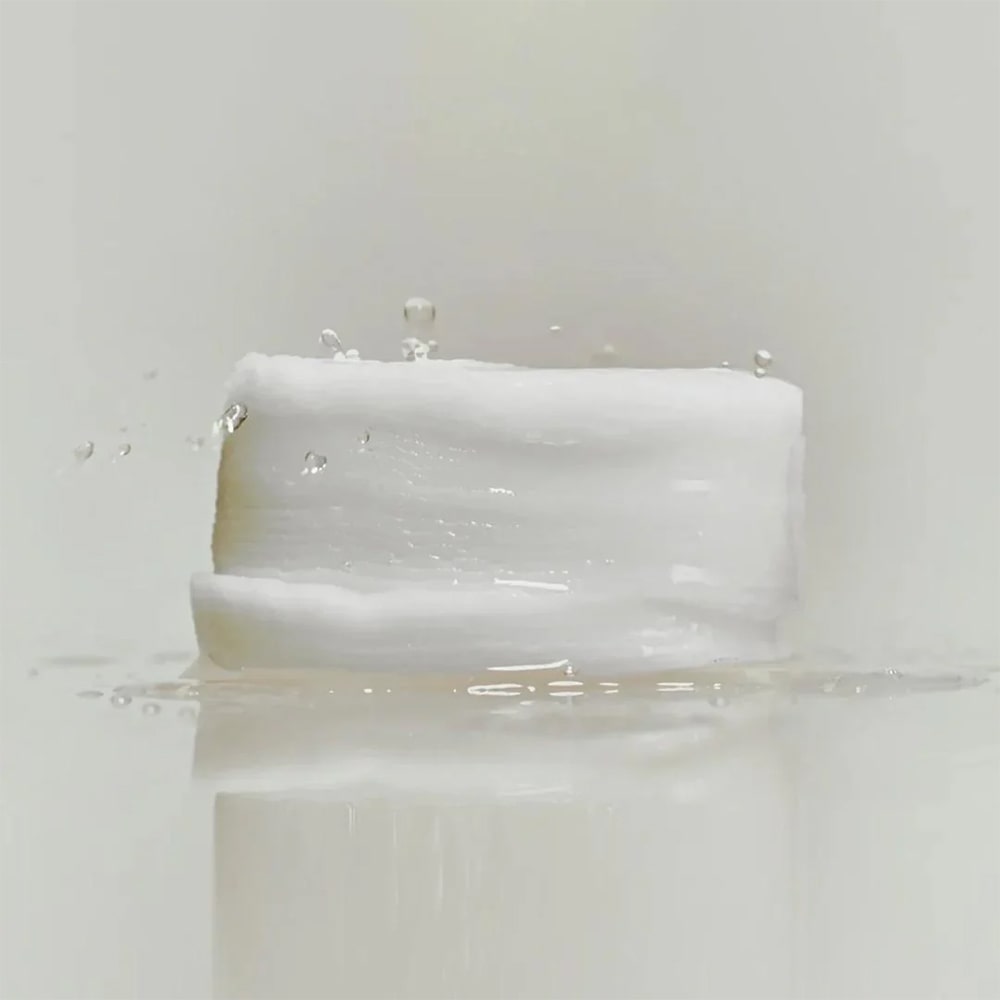 ABIB Jericho Rose Collagen Pad Firming Touch 60 Pads reflecting light with water droplets on a white background.