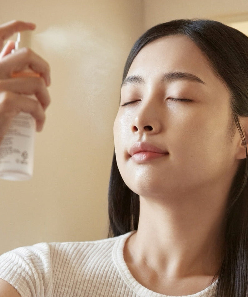 Woman using ABIB Jericho Rose Mist Serum Glow Spray 100ml for a refreshing skincare routine.