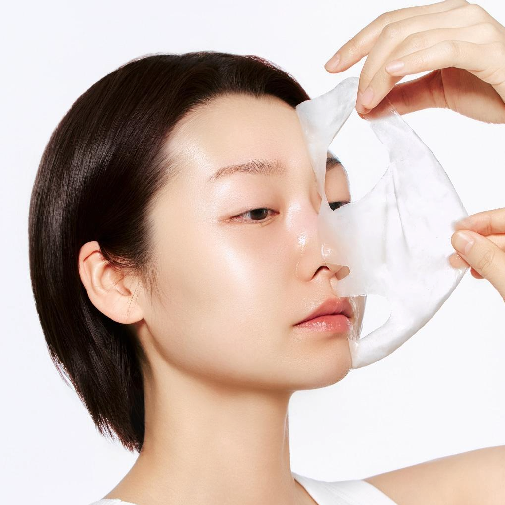 Person using ABIB Lifting Collagen Wrapping Mask Resurrection Film 100ml, applying face mask for skincare routine