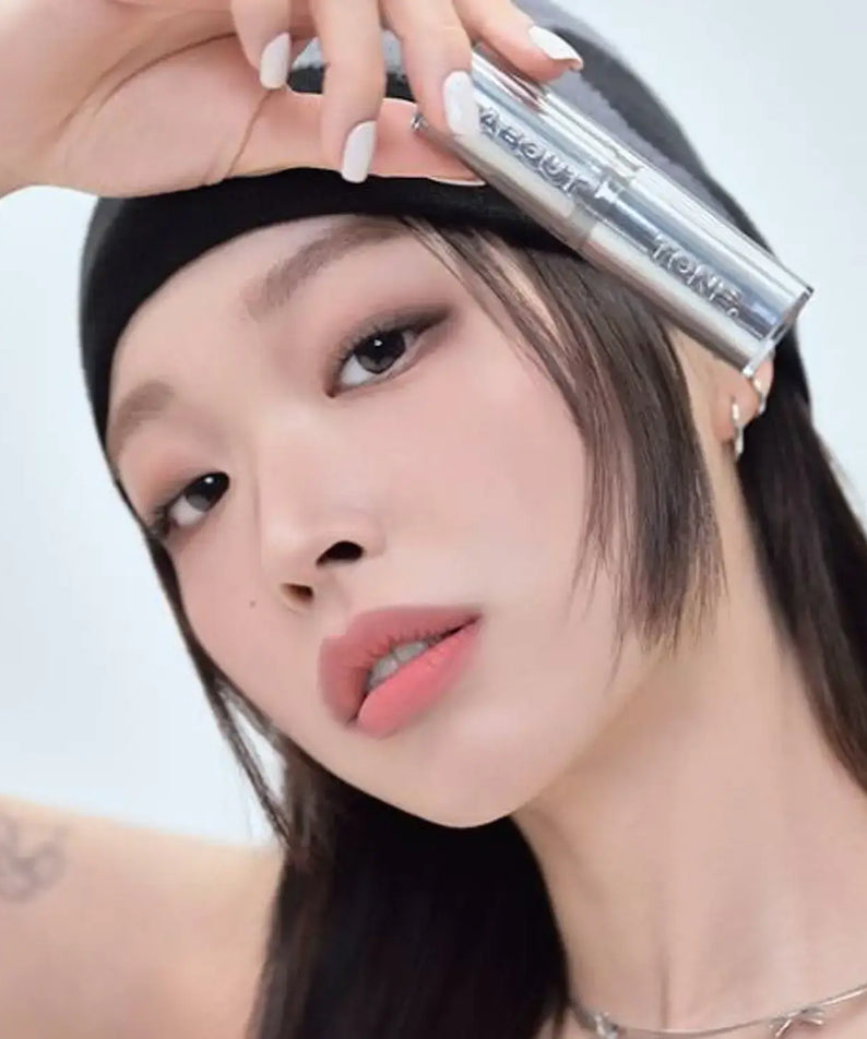 Woman holding ABOUT TONE Blur Lasting Stick Primer