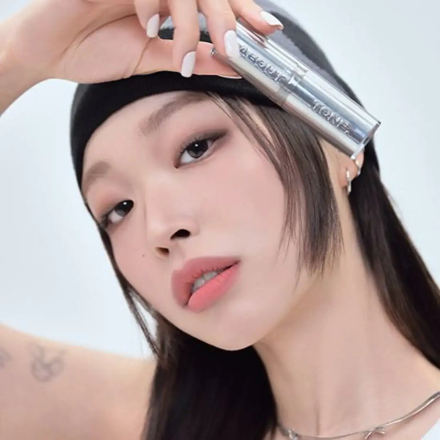 Woman holding ABOUT TONE Blur Lasting Stick Primer
