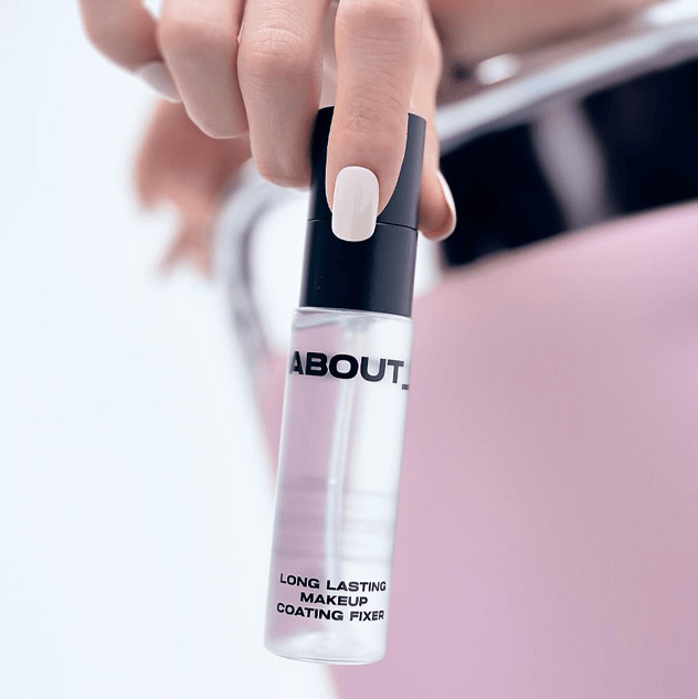 ABOUT TONE Long Lasting Makeup Coating Fixer spray bottle held in hand.