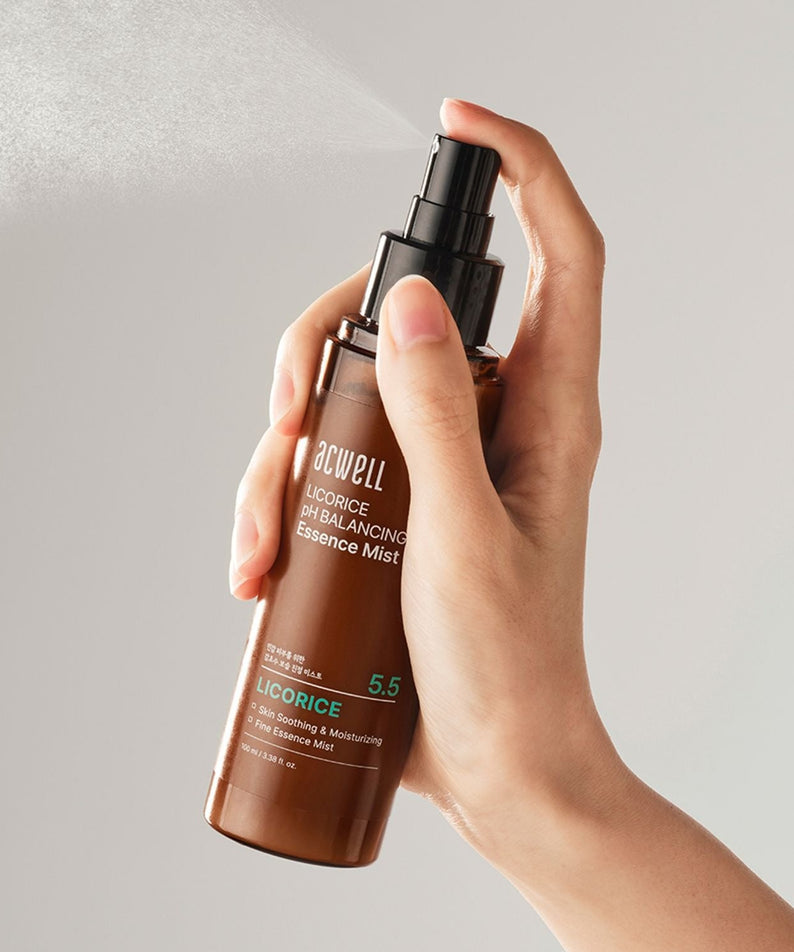 Hand holding ACWELL Licorice pH Balancing Essence Mist 100ml, showing product application.