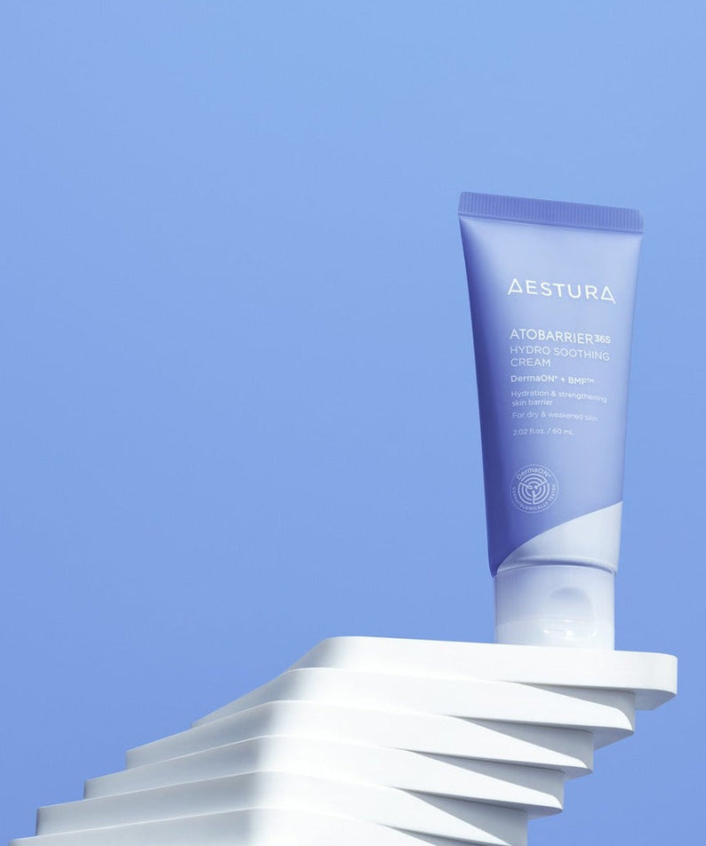 AESTURA Atobarrier 365 Hydro Soothing Cream 60ml tube on abstract white pedestal with blue background