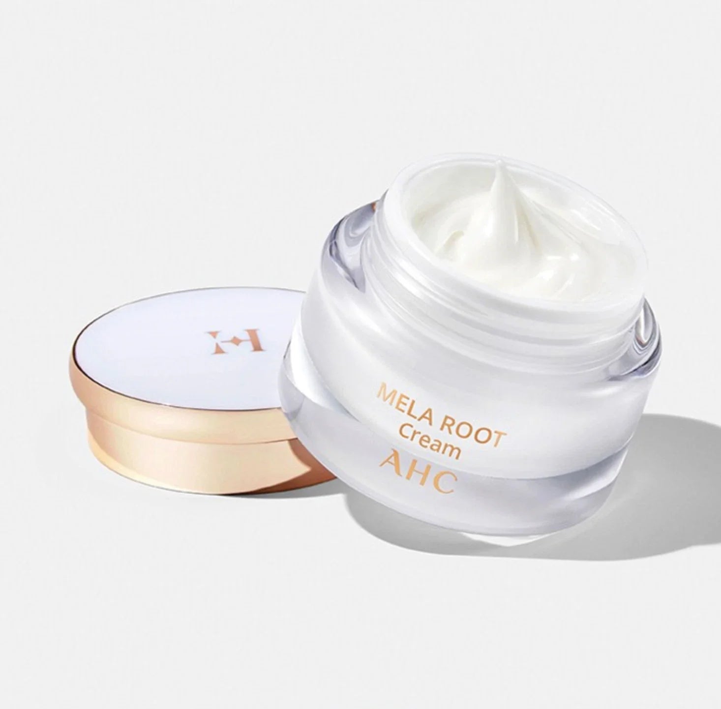 Glass jar of AHC H Mela Root Cream 50ml with a luxurious gold lid, showcasing the creamy texture for skincare enthusiasts.