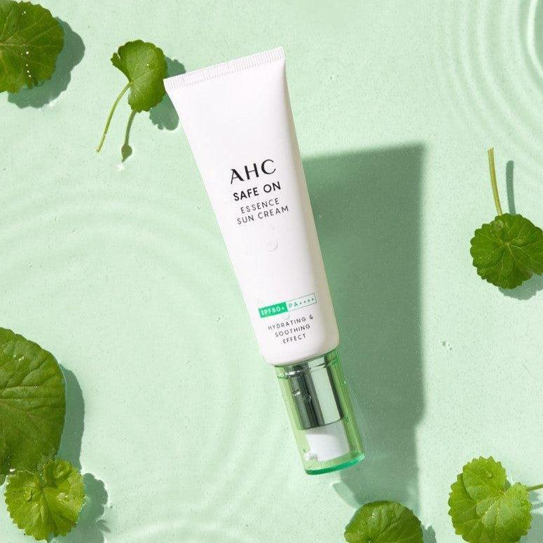 AHC Safe On Essence Sunscreen 50ml displayed on a green leaf background, highlighting its hydrating formula.