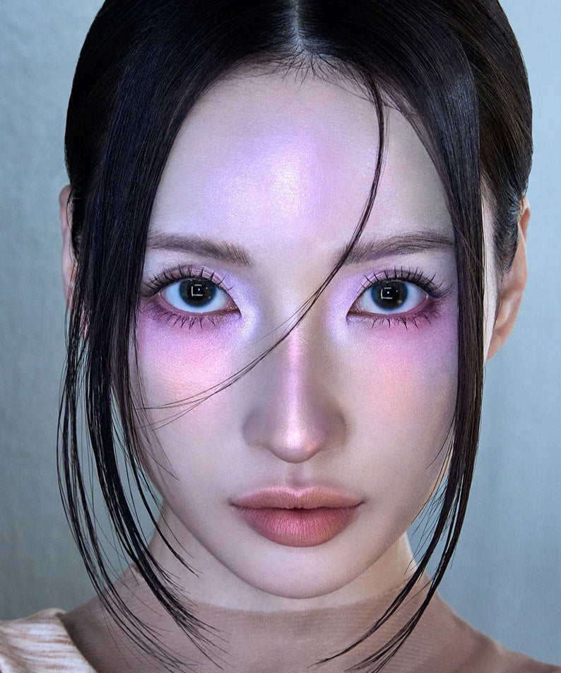 Portrait of a person with striking makeup and illuminated skin