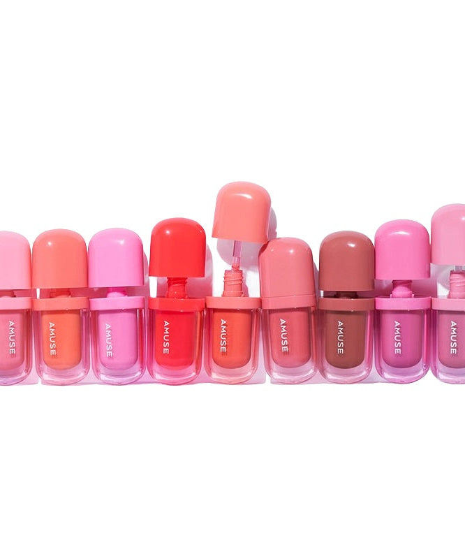 Colorful selection of AMUSE BEBE TINT lip products in various shades, beautifully arranged in a row.