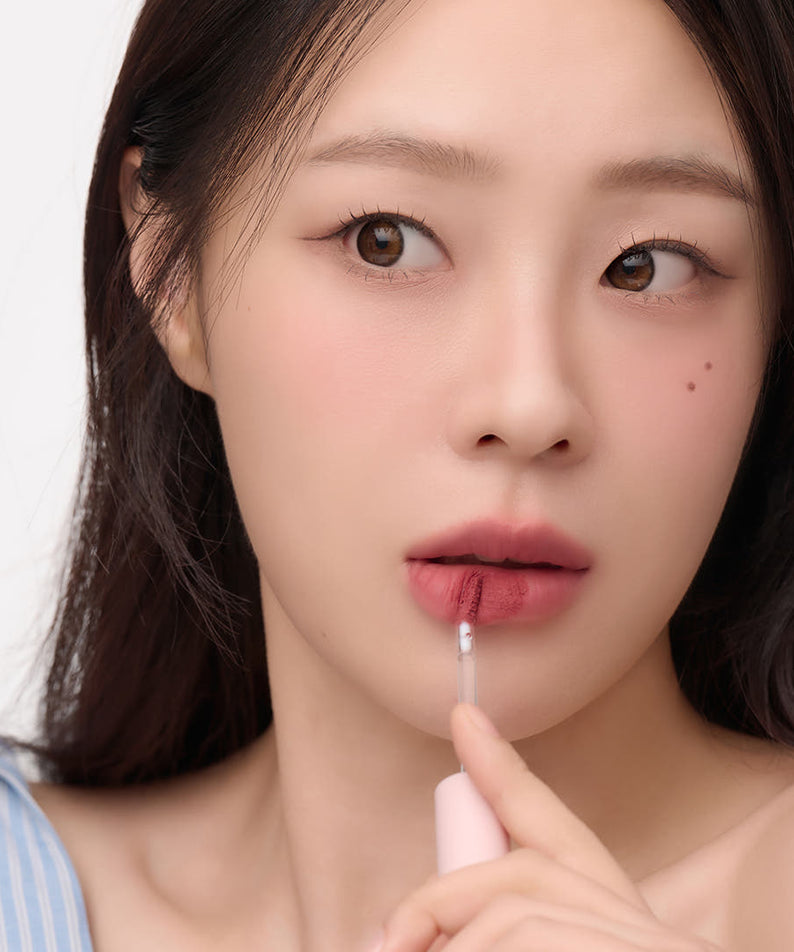 Woman applying AND:AR Matte Lip Color for a natural look