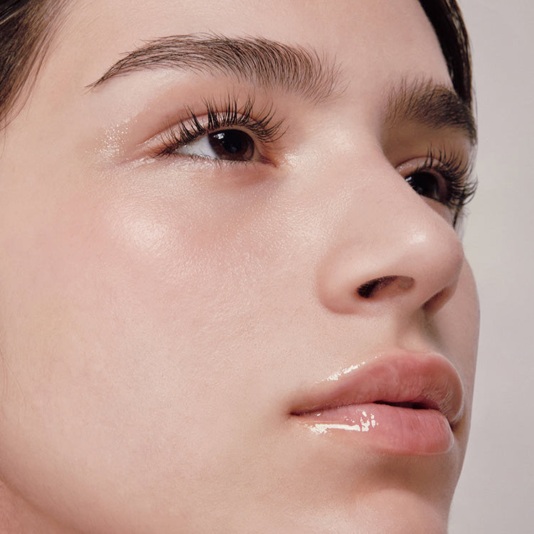 Close-up of a person showcasing a radiant complexion using ANILLO Mellow Glow Balm.