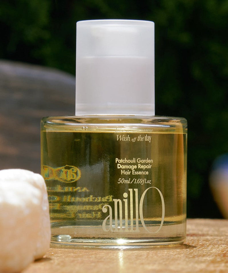 ANILLO Patchouli Garden Damage Repair Hair Essence 50ml bottle on wooden surface outdoors
