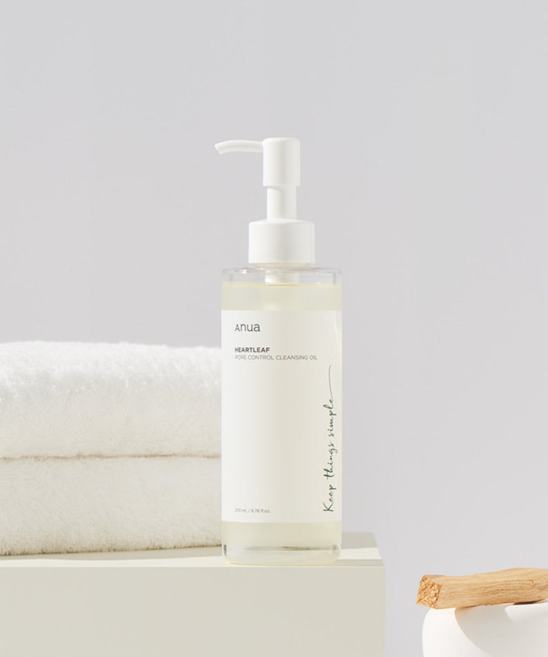 ANUA Heartleaf Pore Control Cleansing Oil 200ml bottle on a bathroom counter with towels in the background