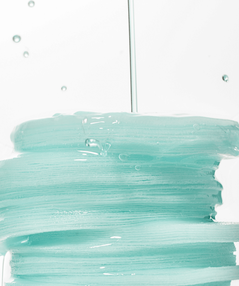Stack of wet ANUA PDRN 100 Hyaluronic Acid Glow Pad with liquid dripping