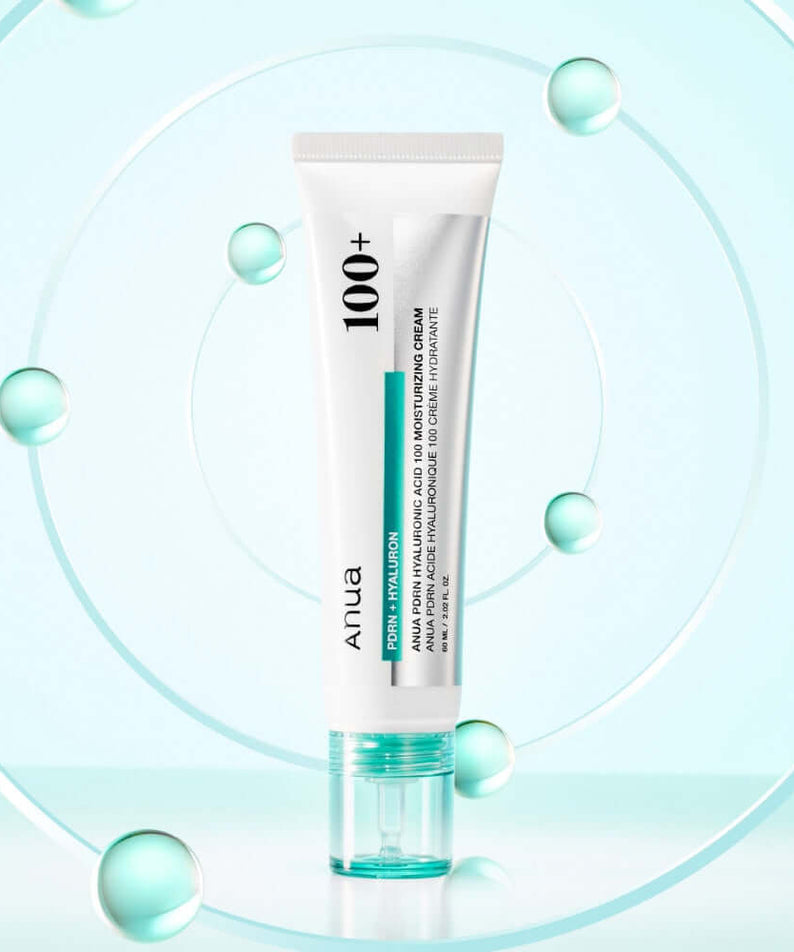 ANUA PDRN Hyaluronic Acid 100 Moisture Cream in a sleek tube with a blue cap, surrounded by water droplets for hydration emphasis.