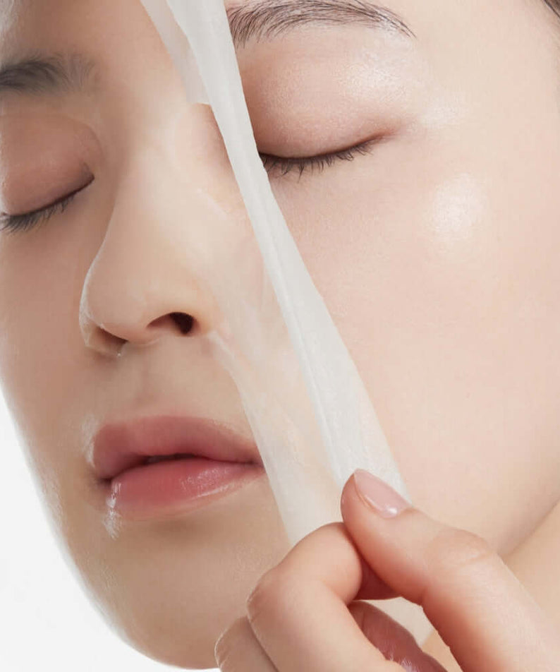 Person applying ANUA PDRN Hyaluronic Acid Capsule 100 Serum Mask for skincare treatment.
