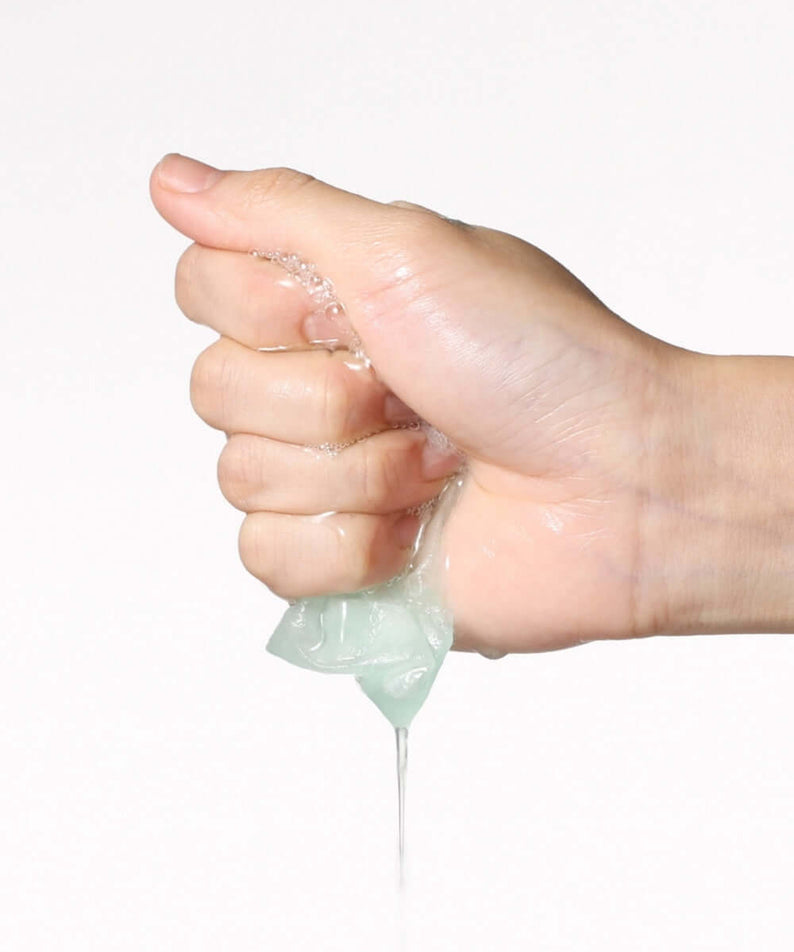 Hand squeezing ANUA PDRN Hyaluronic Acid Capsule 100 Serum Mask with serum dripping out for skincare nourishment