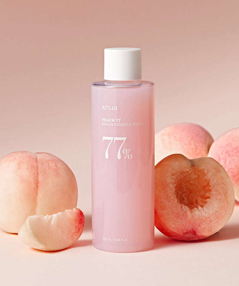 ANUA Peach 77 + Niacin Essence Toner 250ml bottle with fresh peaches background