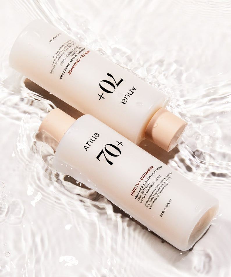 ANUA Rice 70 + Ceramide Glow Milky Toner 250ml bottles submerged in water