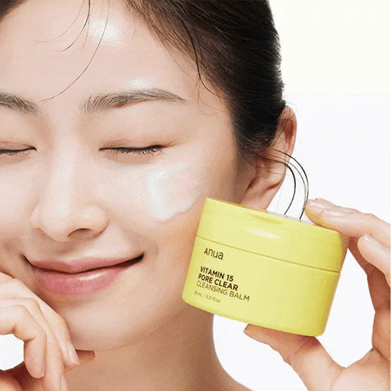 Smiling person holding ANUA Vitamin 15 Pore Clear Cleansing Balm 95ml against skin